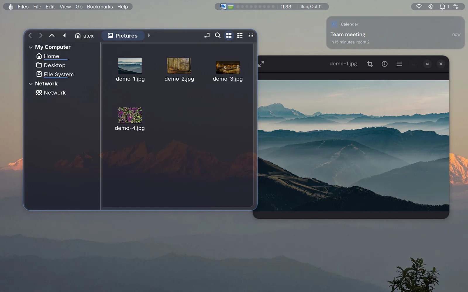 The desktop with its bar, a file manager and an image viewer on the wallpaper.